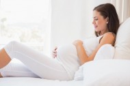 42592719 - happy pregnancy sitting on sofa at home in bedroom