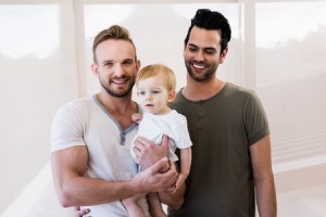 52102476 - smiling gay couple with child at home