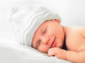 15230655 - smiling european newborn baby in white hat
